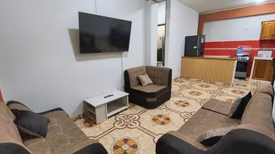 a living room with a couch and a chair and a flat screen tv at Departamentos Sumaq Plaza - Libertad in Ayacucho