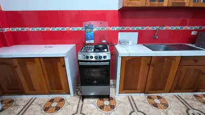 a small kitchen with a stove and a sink at Departamentos Sumaq Plaza - Libertad in Ayacucho