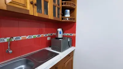 a kitchen with a sink and a microwave at Departamentos Sumaq Plaza - Libertad in Ayacucho