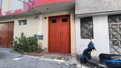 a scooter parked in front of a building with a red door at Departamentos Sumaq Plaza - Libertad in Ayacucho