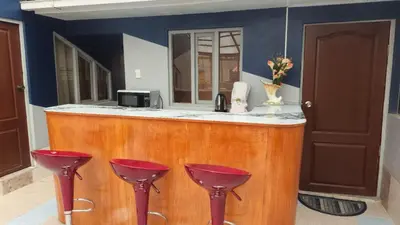 a kitchen with a bar with two red stools at Cozy Mini-Apartment-Cusco in Cusco