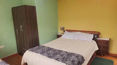 a bedroom with a bed and a dresser at Cozy Mini-Apartment-Cusco in Cusco
