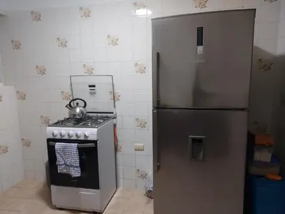 a kitchen with a stainless steel refrigerator and a stove at KUSIHaus in Lima