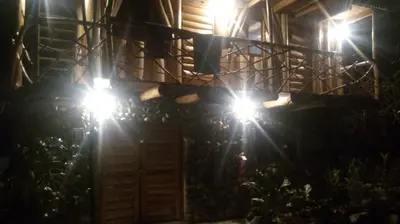 two lights on the side of a house at night at Glamping Machupicchu Lodge in Santa Teresa