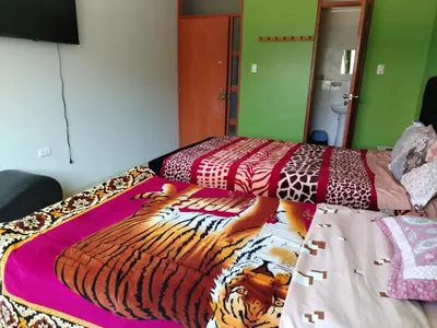 a bedroom with a bed with a tiger blanket on it at Hospedaje el Mirador del Pillcomozo in Huánuco