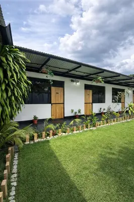 a house with a green lawn in front of it at La Posada de Chango in La Merced
