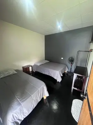 a room with two beds and a lamp in it at La Posada de Chango in La Merced