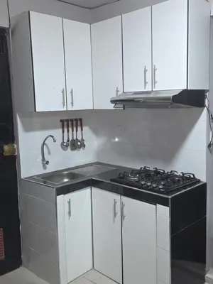 a kitchen with a stove and white cabinets at Mar y luz in Lima