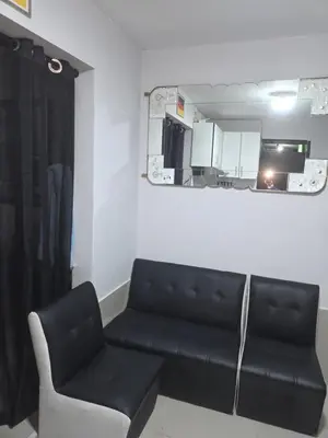 a living room with a black couch and a kitchen at Mar y luz in Lima