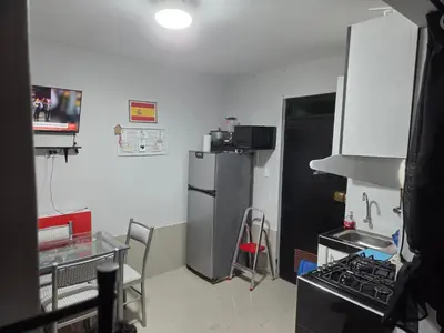 a small kitchen with a refrigerator and a stove at Mar y luz in Lima
