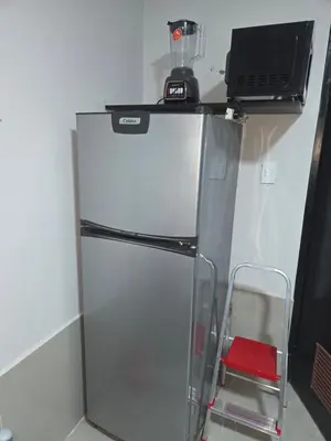 a refrigerator with a microwave on top of it at Mar y luz in Lima