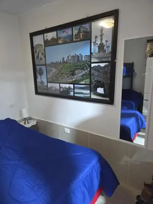 a bedroom with two beds and a large mirror at Mar y luz in Lima