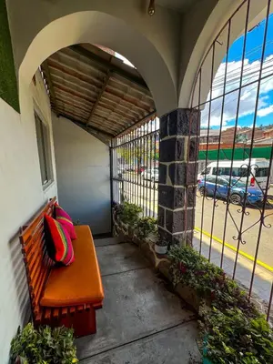 a bench with a bag sitting on it on a porch at Imperium House Cusco in Cusco