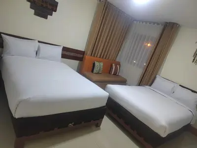 a hotel room with two beds and a chair at Imperium House Cusco in Cusco