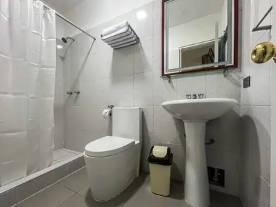 a white bathroom with a toilet and a sink at Imperium House Cusco in Cusco