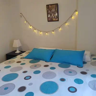 a bedroom with a bed with blue pillows at Elite Apartment in Cusco
