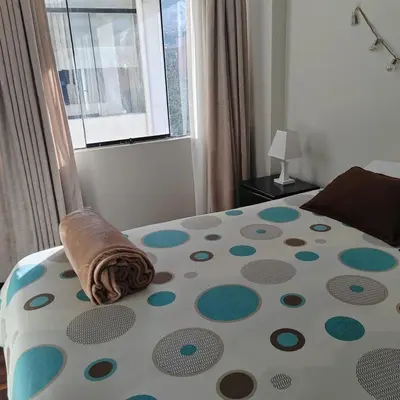 a bedroom with a bed with a polka dot pattern at Elite Apartment in Cusco