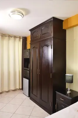 a kitchen with brown cabinets and a refrigerator at Hostel Esperanza in Lima
