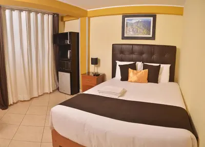 a bedroom with a large bed with a black headboard at Hostel Esperanza in Lima