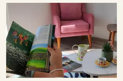 a person reading a book in a living room at Milyshomeperu in Lima