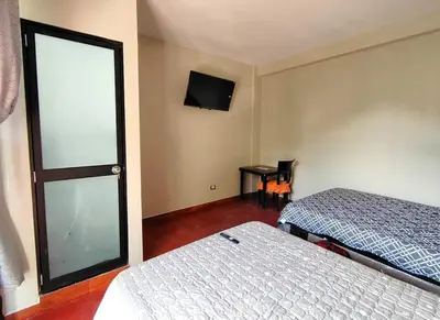 a room with two beds and a tv and a window at Casa de campo familiar cn parrilla, WiFi y piscina
