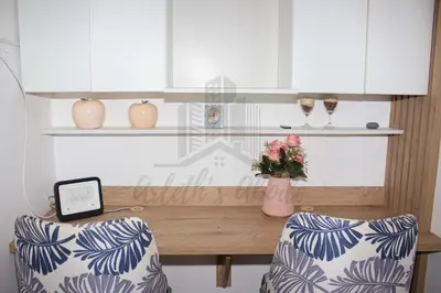 a table with a vase of flowers and two chairs at Cozy apartment in San Miguel in Lima