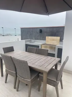 a wooden table and chairs with a kitchen in the background at Exclusive apartment in Miraflores in Lima