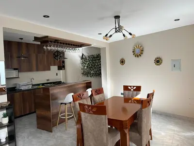 a kitchen and dining room with a wooden table and chairs at Departamento de Estreno Amplio y Confortable in Ayacucho