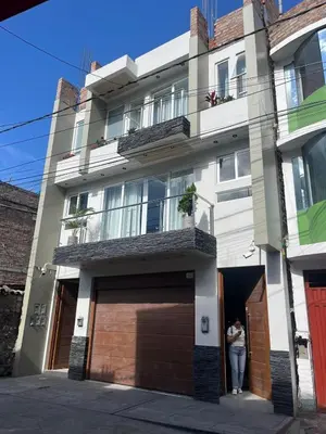 a woman standing in the doorway of a building at Departamento de Estreno Amplio y Confortable in Ayacucho