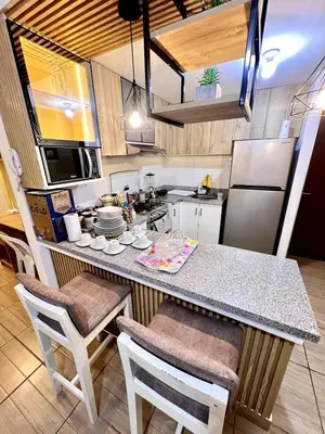 a kitchen with a counter with chairs and a refrigerator at Downtown apartment in a residential area in Lima in Lima