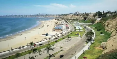 a view of a beach with people and the ocean at Acogedor departamento con cochera in Lima
