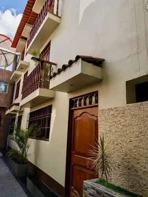 a house with a wooden door and a balcony at Habitación Matrimonial en el centro de la ciudad in Ayacucho