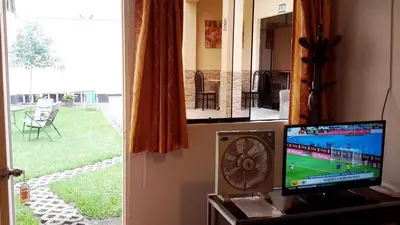 a room with a tv and a view of a yard at Hotel Pradera Verde Inn in Lima