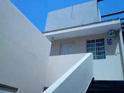 a white building with a staircase and a window at Hotel Pradera Verde Inn in Lima