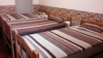 four beds lined up in a row in a room at Hotel Pradera Verde Inn in Lima