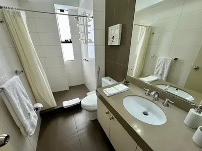 a bathroom with a sink and a toilet and a mirror at Increible vísta al Malecón de Miraflores in Lima