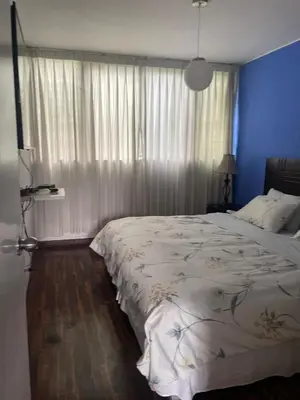a bedroom with a large bed and a blue wall at Miraflores Dpto 3 dormitorios in Lima