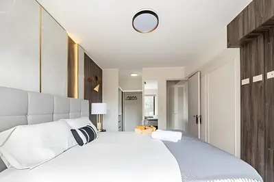 a bedroom with a large white bed with a headboard at Edificio The Classic in Lima