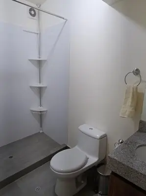 a white bathroom with a toilet and a sink at MiniHome Pietra di Prado in Lima