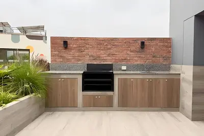 a kitchen with wooden cabinets and a brick wall at Torre Gold in Lima