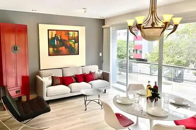 a living room with a white couch and red pillows at Modern Apartment between Miraflores & Surquillo in Lima