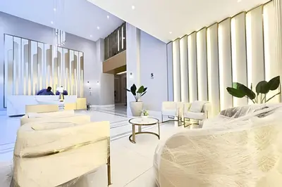 a lobby with white tables and chairs and windows at Torre Platinium in Lima