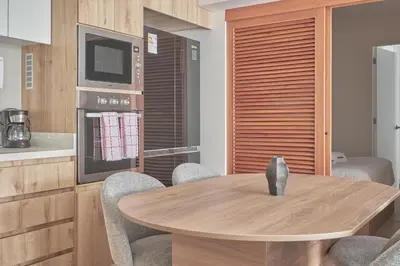 a dining room with a wooden table and chairs at Celestra by Geko in Lima
