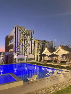 a swimming pool in front of a building at Mystic Paracas Hotel & Glampings in Paracas