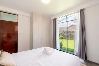 a bedroom with a bed and a large window at Rural Retreat with Charming Patio 2 Bedrooms in Urubamba