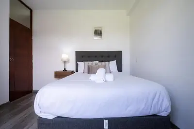 a bedroom with a large white bed with two pillows at Rural Retreat with Charming Patio 2 Bedrooms in Urubamba