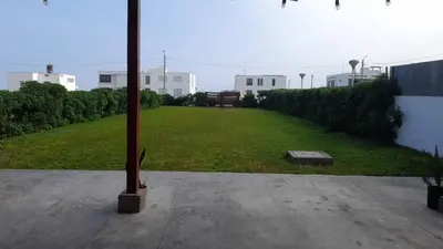 a large yard with a pole in the middle of it at Casa amplia con jardín frente al mar in Lurín