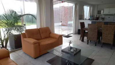 a living room with a couch and a table at Casa amplia con jardín frente al mar in Lurín
