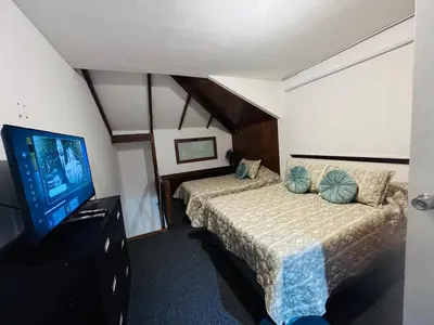 a hotel room with two beds and a flat screen tv at Monterrico Polo Apart 4 - Frente Embajada USA in Lima