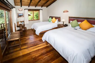 two beds in a room with wooden floors at Dreamy cabins in Urubamba